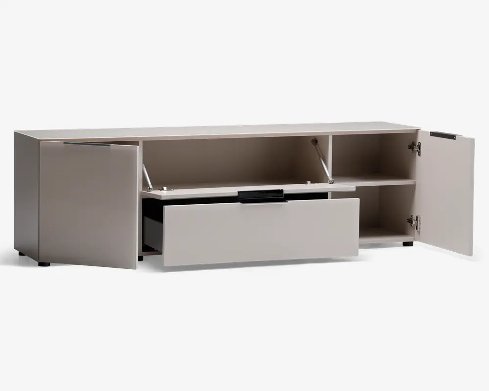 Rektangulær opbevaringsenhed i lys beige farve med et moderne, minimalistisk design. Har to sidekabinetter med hængslede låger, hver med en hylde til organisering. Midtersektionen har et vandret rum med en opadgående låge, der understøttes af metalarme, og nedenunder er der en bred udtræksskuffe med sort greb. Enheden står på korte, skjulte ben, hvilket giver et stilrent, svævende udtryk.