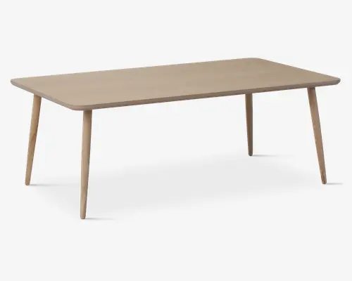 Rektangulært bord med en glat, lys træfinish. Bordet har afrundede hjørner og let tilspidsede ben, der står skråt udad for ekstra stabilitet. Designet er minimalistisk og moderne med en rummelig bordplade, der egner sig til både spisning og arbejde.