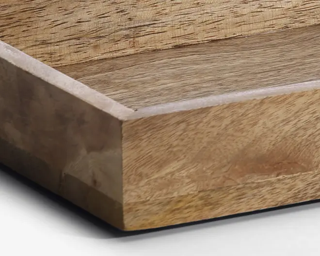 Nærbillede af en genstand i træ med glatte, slebne overflader og synlige naturlige åremønstre. Kanterne er lige og pænt sammensat, og finishen er mat, hvilket fremhæver træets struktur og farvevariationer.