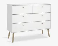 En moderne hvid kommode med minimalistisk design, der har fire skuffer – to mindre øverst og to større nedenunder. Hver skuffe har en lille rund træknop. Kommoden står på fire skråtstillede ben i lyst træ, hvilket giver den et udtryk i retrostil.