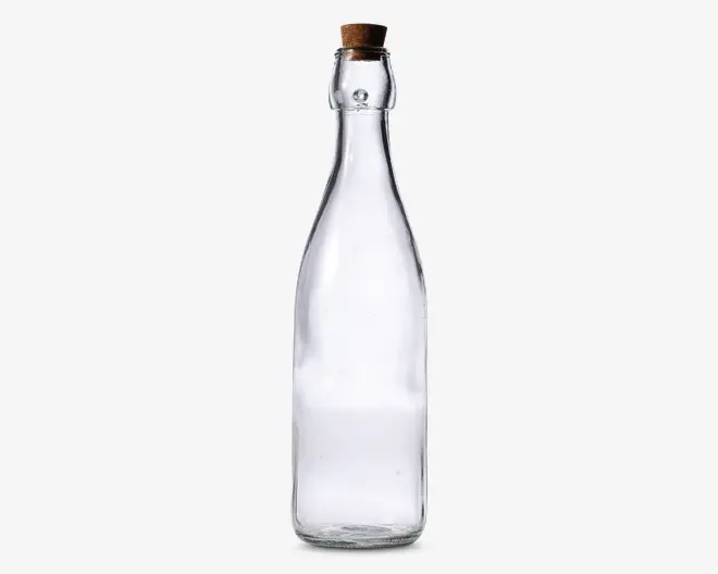Klar glasflaske med en høj, slank hals og en bredere bund. Flasken er lukket med en naturlig korkprop. Glasset er glat og gennemsigtigt, så indholdet let kan ses. Designet er enkelt og elegant, velegnet til opbevaring af væsker som vand, olie eller eddike.