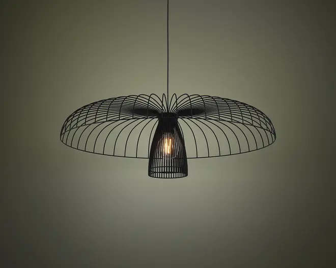 En moderne loftslampe med et sort trådramme-design. Skærmen er bred og cirkulær, og ligner en åben paraply eller blomst, hvor tynde metalstænger stråler ud fra midten. Pæren er synlig og hænger i midten, omgivet af et mindre cylindrisk trådbur. Lampen har et minimalistisk og nutidigt udtryk, og den åbne struktur lader lyset passere frit igennem.