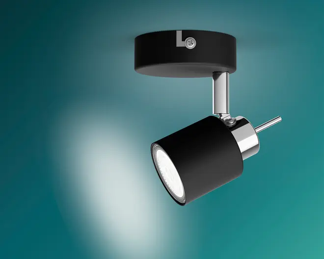 En elegant, sort, justerbar spotlampe med cylindrisk lampeshoved, forkrommet støttearm og rund loftsmontering, vinklet nedad for at kaste en fokuseret lysstråle.