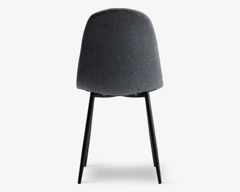 Stol med buet, polstret ryglæn i mørkegråt stof. Bagsiden er glat og rundet uden synlige syninger eller knapper. Stolen har slanke, sorte metalben, der er let udadgående for stabilitet.