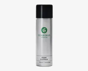Høj, cylindrisk spraydåse med sølvfarvet krop og sort låg. Forsiden har et grønt logo og teksten 'Guardian Furniture Care' i grønt, samt 'Foam Cleaner' i sort nedenunder. Dåsen har et moderne og stilrent design, der er let at holde om. Produktet er beregnet til rengøring, hvilket fremgår af etiketten.