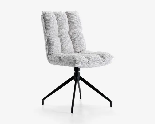 Stol med blødt, tekstureret lysegråt betræk og dybe vandrette og lodrette syninger på sæde og ryglæn for ekstra komfort. Sædet er kraftigt polstret, og ryglænet er let vinklet. Stolen står på en sort metalbase med fire skråtstillede ben, hvilket giver stabilitet og et moderne udtryk.