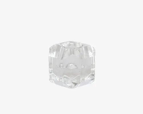Klar, facetslebet glasholder med en geometrisk, sekskantet form. Siderne er glatte og polerede, og toppen har en cirkulær fordybning, der passer til et lille lys eller fyrfadslys. Glasset er tykt, hvilket giver et robust og elegant udtryk.