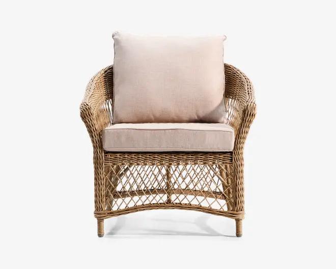 Lænestol med stel af naturlig rattan og flettet gitterdesign på sider og front. Stolen har høj, let buet ryg og afrundede armlæn. Den er udstyret med tykke, aftagelige beige hynder til sæde og ryg for ekstra komfort.