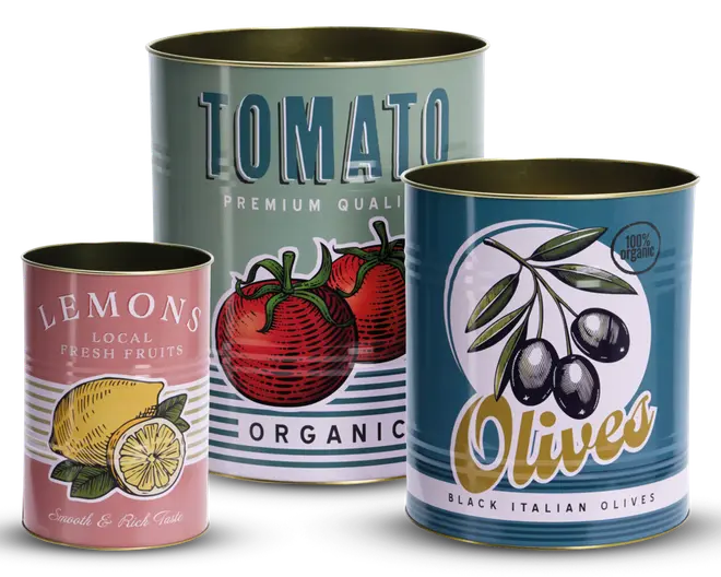 Tre cylindriske metaldåser med retro-inspirerede etiketter. Den første dåse er lyserød med en illustration af en gul citron og grønne blade samt hvid tekst, der viser en hel og en skåret citron. Den anden dåse er lyseblå-grøn med store blå bogstaver og en illustration af to røde tomater med grønne stilke, mærket som økologisk og premium kvalitet. Den tredje dåse er mørkeblå med en hvid cirkel, der indeholder en gren med sorte oliven og grønne blade, mærket som 100% økologiske sorte italienske oliven. Alle dåser har guldfarvede kanter og en mat overflade.