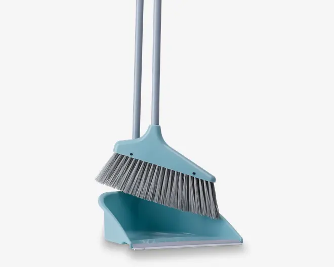 Et lyseblåt rengøringssæt bestående af en kost med bløde, skrå grå børster og en matchende fejebakke. Begge dele har lange, sølvfarvede håndtag, så de er behagelige at bruge stående. Fejebakken har en flad kant for effektiv opsamling af snavs og en dyb beholder til at holde det opsamlede skidt. Kosten og fejebakken kan sættes sammen for pladsbesparende opbevaring.