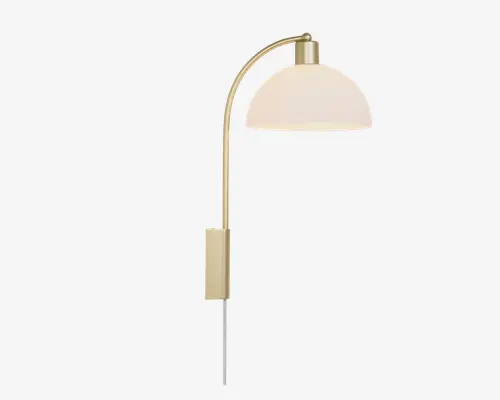 En moderne væglampe med børstet messingfinish. Lampen har en let buet arm, der rækker udad og bærer en kuppelformet, mat hvid lampeskærm. Designet er slankt og minimalistisk med en rektangulær vægplade og en synlig ledning, der hænger nedad til tilslutning i stikkontakt.
