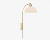 En moderne væglampe med børstet messingfinish. Lampen har en let buet arm, der rækker udad og bærer en kuppelformet, mat hvid lampeskærm. Designet er slankt og minimalistisk med en rektangulær vægplade og en synlig ledning, der hænger nedad til tilslutning i stikkontakt.