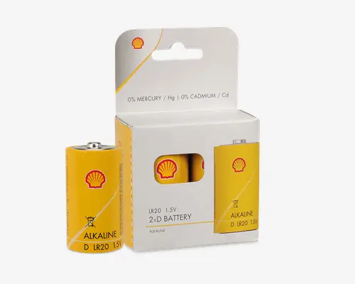 To gule D-størrelse alkalinebatterier med et rødt Shell-logo, pakket i en hvid æske med et udskåret vindue, der viser et af batterierne indeni. Emballagen fremhæver, at batterierne indeholder 0 % kviksølv og 0 % cadmium. Batterierne er mærket "LR20 1.5V" og "ALKALINE" med sort tekst. Æsken har en ophængningsfane til udstilling.