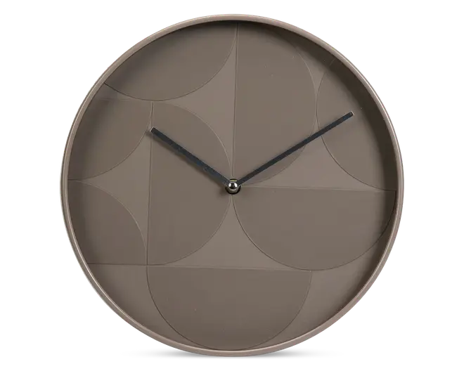 Rund vægur med mat taupe-finish og et diskret geometrisk mønster præget på urskiven. Uret har minimalistiske sorte time- og minutvisere uden tal eller markeringer, hvilket giver et moderne og stilrent udtryk.