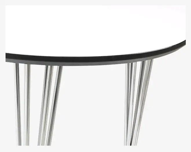 Nærbillede af et bord med en glat, rund hvid bordplade og sort kant. Bordet har fire skrå, krombelagte metalben, der giver et moderne og solidt udtryk.