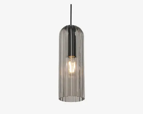 Hængelampe med en høj, cylindrisk glasskærm med lodrette rillede detaljer. Glasset har en røgfarvet tone, som giver et moderne og elegant udtryk. Pæren er synlig inde i lampen, hvilket tilføjer et industrielt præg, og lampen hænger i en slank, metalstang.