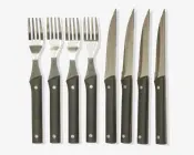 Sæt med fire matchende gafler og fire matchende steakknive, alle med sorte håndtag og to synlige metalnitter. Håndtagene er lige og har en mat overflade, mens knivbladene er savtakkede til udskæring. Gaffel-tænderne er jævnt fordelt, og det samlede design er enkelt og moderne.