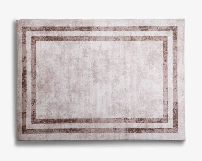 Rektangulært tæppe med en diskret, slidt tekstur i lyse beige nuancer. Designet har to parallelle, brede kanter i en lidt mørkere beige, hvilket skaber en indrammet effekt. Udtrykket er minimalistisk og moderne, velegnet til forskellige indretningstyper.
