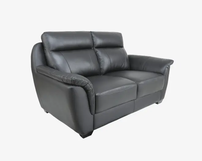 En moderne to-personers sofa betrukket med glat sort læder. Sofaen har bløde, polstrede ryglæn og sædehynder for ekstra komfort. Armlænene er brede og let skrånende, hvilket giver ekstra støtte. Sofaen har en firkantet silhuet med rene linjer, hvilket giver et moderne udtryk.