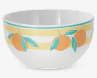Hvid keramikskål med et dekorativt mønster af orange frugter med grønne blade, placeret mod skiftevis gule og hvide vandrette striber nær kanten. Skålen har en glat, blank overflade og en rund form.
