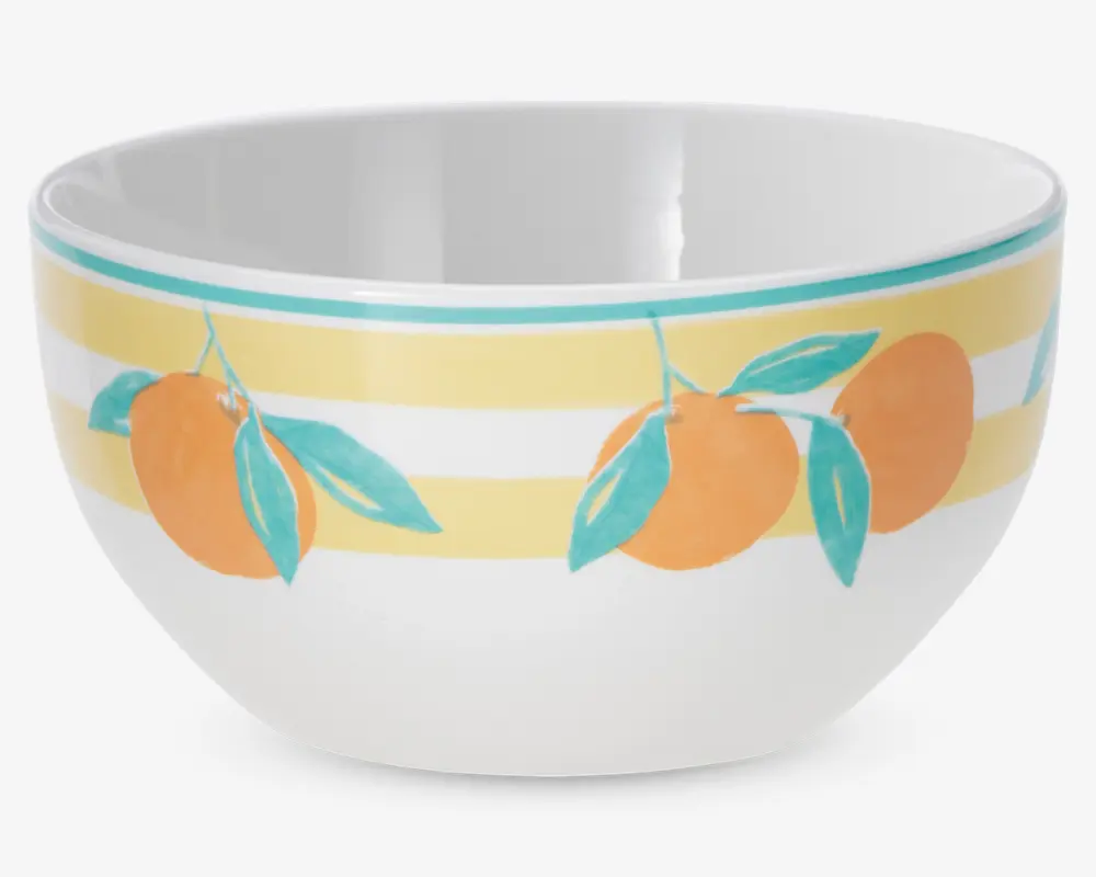 Hvid keramikskål med et dekorativt mønster af orange frugter med grønne blade, placeret mod skiftevis gule og hvide vandrette striber nær kanten. Skålen har en glat, blank overflade og en rund form.