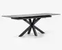 Rektangulært bord med mat sort finish, der har en glat, flad bordplade og et markant geometrisk stel bestående af flere skråtstillede ben, der mødes i midten for et moderne, skulpturelt udtryk. Bordet fremstår robust og rummeligt, velegnet til spise- eller arbejdsbrug.