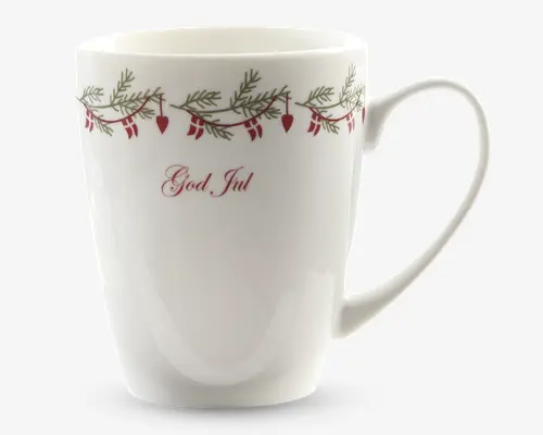 Hvid keramikkop med et festligt design nær kanten, der viser grønne grangrene og røde hængende ornamenter formet som hjerter og kræmmerhuse. Ordene 'God Jul' står skrevet med elegant rød skrift på forsiden. Koppen har en glat, blank overflade og et behageligt, rundt håndtag.