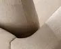 Nærbillede af en beige polstret overflade med tekstureret, boucle-lignende stof. Billedet fremhæver det bløde, fyldige materiale og de præcise syninger langs sømmene, samt produktets bløde kurver og konturer. Stoffet virker slidstærkt og komfortabelt, egnet til daglig brug.