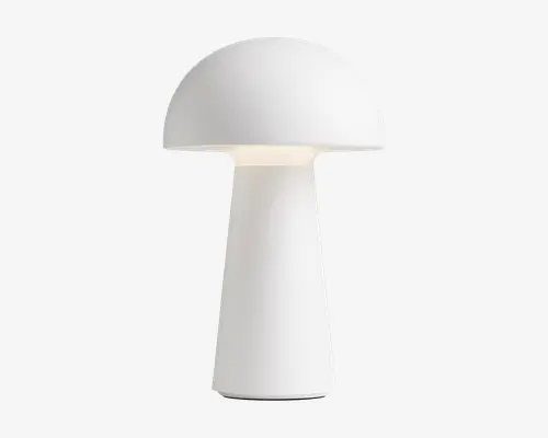 Minimalistisk bordlampe med mat hvid finish, kuppelformet skærm og cylindrisk fod. Lampen har en glat, ensartet overflade og et moderne, svampeinspireret design. Lyset spredes blødt ud under skærmen og giver en behagelig glød.