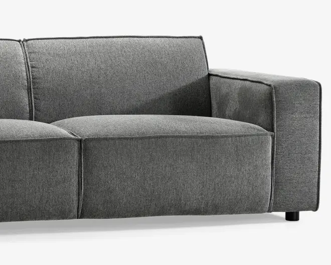 Moderne sofaelement med højre armlæn, betrukket med glat, mørkegråt stof. Designet har brede, bløde sæde- og ryghynder for ekstra komfort, med rene, lige linjer og diskrete syninger. Armlænet er tykt og polstret, og sofaen står på korte, solide ben, hvilket gør den velegnet til moderne stuer.