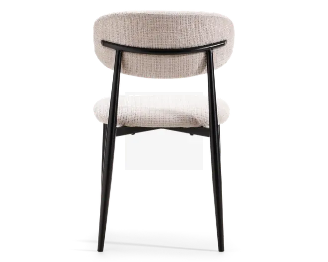 Stol med buet, polstret ryglæn og sæde i et lyst, tekstureret stof. Stellet og benene er lavet af sort metal, hvor bagbenene er vinklet udad for stabilitet. Designet er moderne og minimalistisk med rene linjer og en solid konstruktion.
