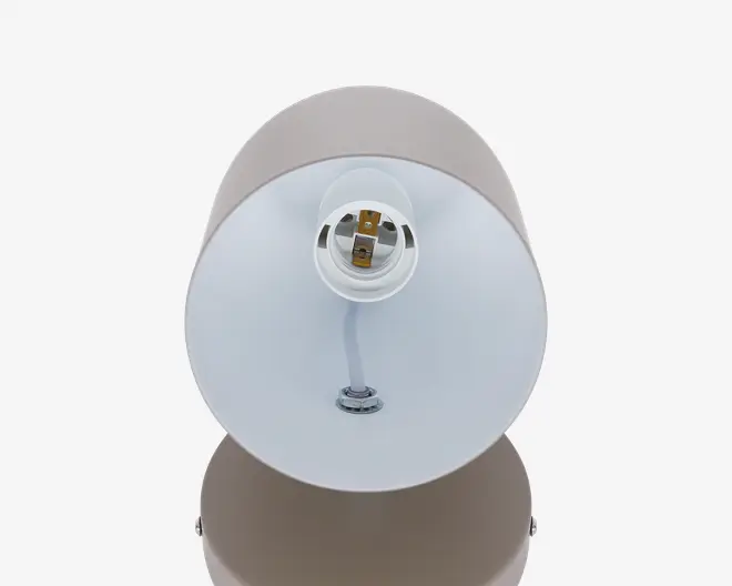 Rund hvid lampebase eller skærm med en central fatningsåbning, en kort hvid ledning ned til en metalmontering og beige yderside synlig øverst og nederst.