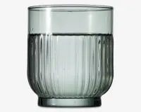 Kort drikkeglas med let afrundet bund og lodret rillet struktur på den nederste halvdel. Glasset er transparent med et diskret gråt skær, og kanten er glat og jævn. Designet giver et moderne og elegant udtryk, velegnet til servering af vand eller andre drikkevarer.