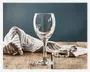 Et klart glas med stilk, rundet skål og let udadbuet kant, velegnet til servering af vin. Glasset står på en rustik træoverflade med en stribet stofserviet i baggrunden, hvilket fremhæver dets gennemsigtighed og klassiske design.