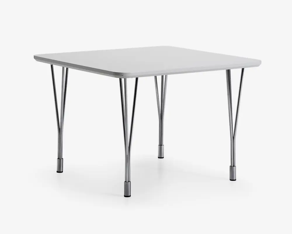 Et firkantet bord med en glat, lysegrå bordplade og afrund sopkanter. Bordpladen understøttes af fire solide, sammen sopklappelige metalben med kromfinish, hver med en trekantet støtte for ekstra stabilitet. platformene har sorte plastikdutter nederst for at beskytte gulvet og forhindre, at bordet glider. Designet er enkelt og funktionelt, velegnet til både indend supporting og **udendørs brug.