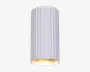 Cylindrisk loftlampe med lodrette riller og mat hvid overflade. Lampens yderside har jævnt fordelte riller, der løber fra top til bund og giver et moderne, struktureret udtryk. Den åbne bund afslører en glat, gylden inderside, som reflekterer et varmt lys, når lampen er tændt.