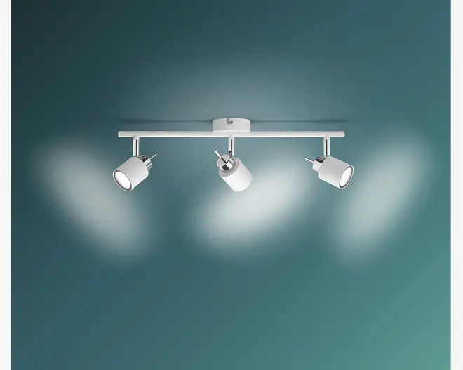 Moderne loftmonteret lampe med en lige, horisontal metalstang i mat hvid finish. Lampen har tre justerbare cylindriske spotlys, hver med en glat hvid yderside og sølvfarvede detaljer ved basen. Spotlysene kan drejes individuelt for at belyse forskellige områder. Designet er minimalistisk og passer til moderne indretning.
