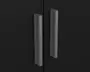 Nærbillede af to lodrette, matgrå håndtag monteret på en sort, glat overflade. Håndtagene har et moderne, minimalistisk design med en let buet profil, der gør dem nemme at gribe om.