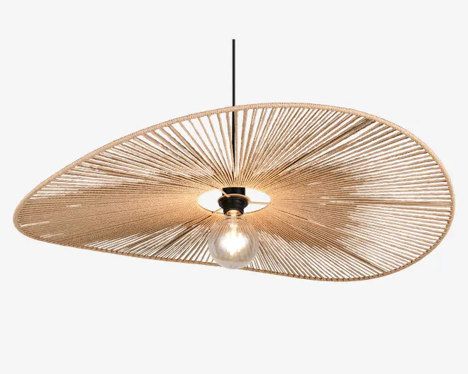 Loftlampe med en stor, asymmetrisk skærm formet som en skive, lavet af tæt vævede naturfibre, der danner et solstrålemønster. Skærmen har et åbent center, hvor pæren er synlig, hvilket giver direkte belysning. Lampen hænger i en sort ledning og har et minimalistisk, moderne udtryk med en varm, organisk tekstur.