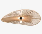 Loftlampe med en stor, asymmetrisk skærm formet som en skive, lavet af tæt vævede naturfibre, der danner et solstrålemønster. Skærmen har et åbent center, hvor pæren er synlig, hvilket giver direkte belysning. Lampen hænger i en sort ledning og har et minimalistisk, moderne udtryk med en varm, organisk tekstur.