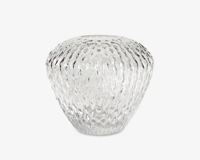 Klar glasvase med rund, bulet form og en smal åbning øverst. Overfladen har et tekstureret, prikket mønster, der skaber en bølget effekt og giver vasen et moderne og elegant udtryk.