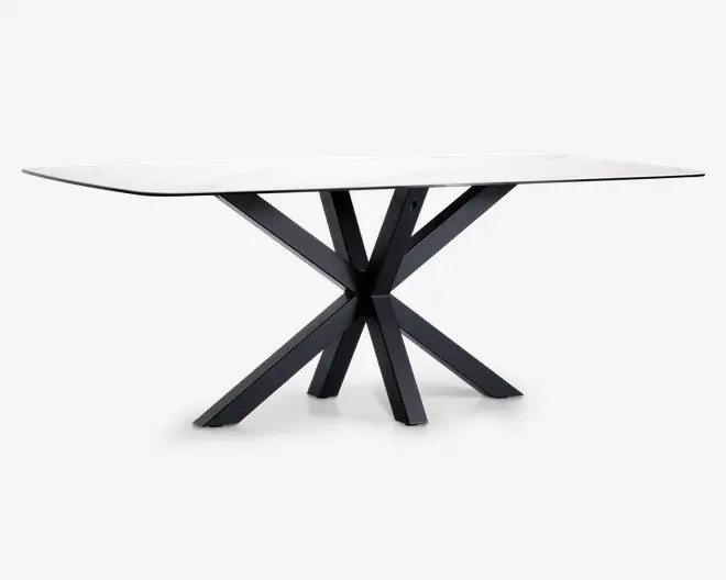 Rektangulært bord med en glat, hvid marmorbordplade og et moderne, geometrisk sort metalstel med skrå ben, der mødes i midten og giver et markant, skulpturelt udtryk.