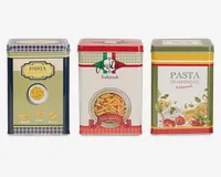Tre rektangulære metaldåser med dekorative designs inspireret af traditionel italiensk pastaemballage. Hver dåse har farverige illustrationer og tekst, med motiver som pastatyper, tallerkener med pasta, tomater og krydderurter. Dåserne har forskellige farveskemaer: én med blå og cremefarvede tern, én med grønne og røde striber samt en tallerken med pennepasta, og én med olivengrønne og røde kanter, dekoreret med billeder af forskellige pastatyper og grøntsager. Alle dåser har tætsluttende låg og er velegnede til opbevaring af tørvarer.