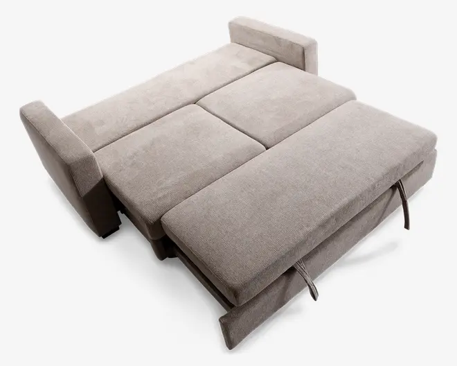 Et møbel betrukket med lysebeige stof vises her i udslået position, så det danner en flad liggeflade. Designet har to armlæn på hver side og en opdelt madrasflade med synlige syninger, der adskiller sektionerne. Foran ses stofhåndtag, som indikerer en nem udtræksmekanisme til at skifte mellem sidde- og liggefunktion. Overfladen ser polstret og støttende ud, velegnet til brug som seng.