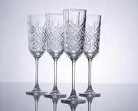 Sæt med fire klare krystalglas med lange stilke og et klassisk slebet diamantmønster på glasskålen. Glassene har en høj, smal form, der er ideel til servering af mousserende drikke. Det indviklede graverede design giver et elegant og sofistikeret udtryk.