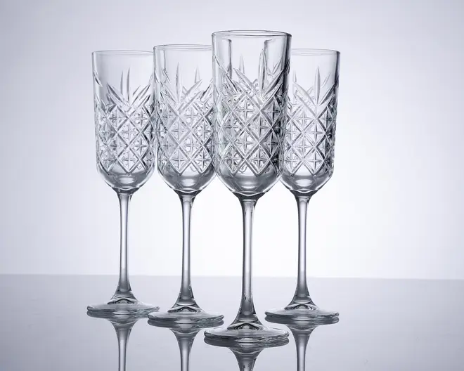 Sæt med fire klare krystalglas med lange stilke og et klassisk slebet diamantmønster på glasskålen. Glassene har en høj, smal form, der er ideel til servering af mousserende drikke. Det indviklede graverede design giver et elegant og sofistikeret udtryk.