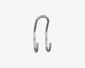 En metal dobbeltkrog med et glat, buet design og børstet finish. Krogen har to monteringshuller til sikker fastgørelse på væggen og to afrundede ender til ophængning af genstande. Det overordnede udseende er slankt og moderne, velegnet til både hjemmet og kontoret.