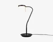 Elegant, moderne skrivebordslampe med mat sort finish. Lampen har en rund, flad fod for stabilitet og en fleksibel, justerbar svanehalsarm, så lyset kan rettes præcist. Lampens hoved er cirkulært og udsender et blødt, fokuseret lys, ideelt til læsning eller arbejde. Synlig ledning går ud fra lampens fod.