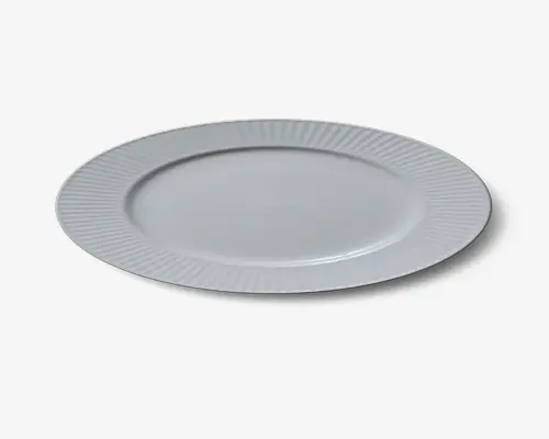 Rund hvid tallerken med bred kant, der har et diskret, jævnt fordelt rillet mønster. Midten er glat og flad, velegnet til servering af mad. Designet er minimalistisk og elegant, hvilket gør den alsidig til forskellige borddækninger.