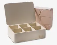 Rektangulær opbevaringsboks med hængslet låg og seks indvendige rum til organisering. Ydersiden er glat og lysebeige med ordet 'Tea' trykt i guld på fronten. Bagsiden af boksen har et geometrisk, præget mønster, der giver et dekorativt udtryk.